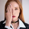 نمای نزدیک از حکاکی ظریف نشان شمس روی پلاک طلایی گردنبند اونیکس دانژه با درخشش سنگ صیقلی مشکی