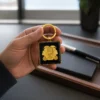 جاسوئیچی طلایی ماه خرداد دانژه قرار گرفته روی دست برای نمایش ابعاد و ظرافت ساختار لوکس آن